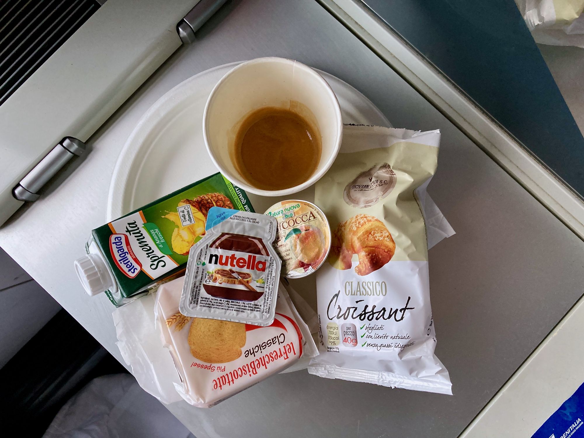 Frühstück im Schlafwagen: Kaffee, Saft, Zwieback, Croissant, Marmelade und Nuss-Nougat-Creme