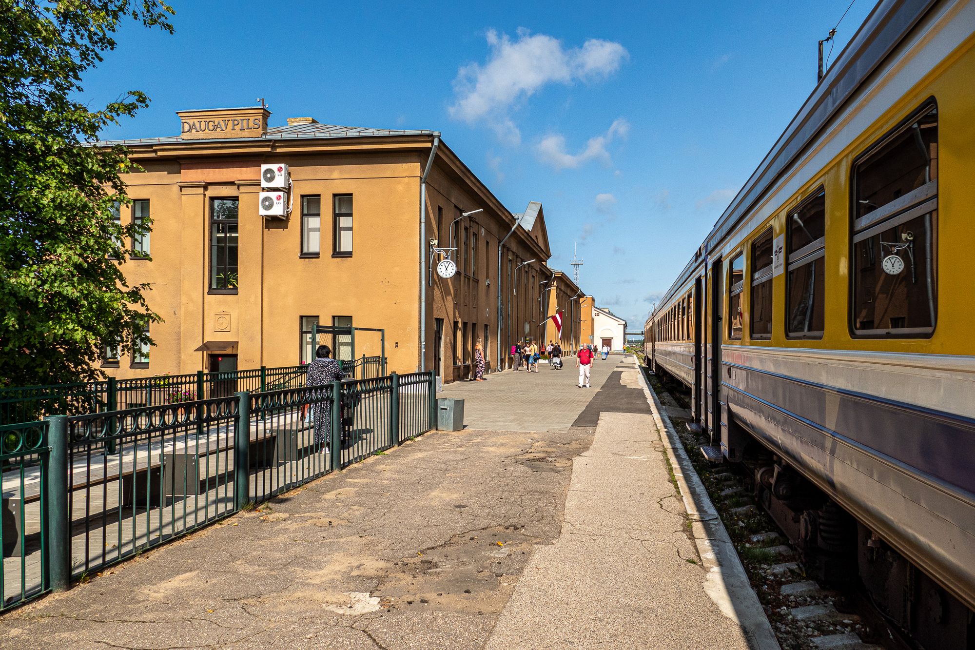 Bahnhof Daugavpils mit Bahnhofsgebäude, Zug und Bahnsteig