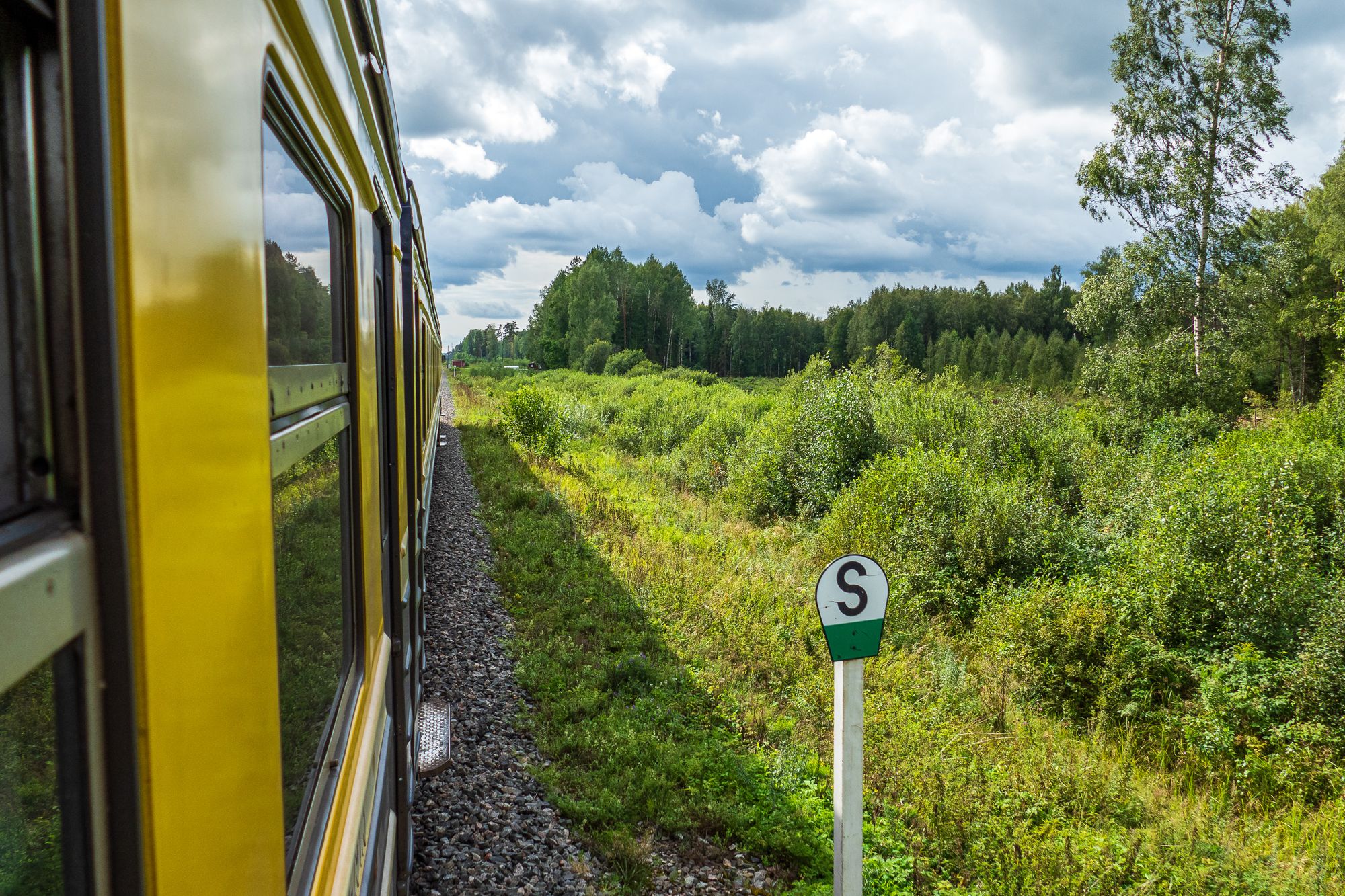 Blick aus dem offenen Zugfenster auf der Fahrt durch Lettland