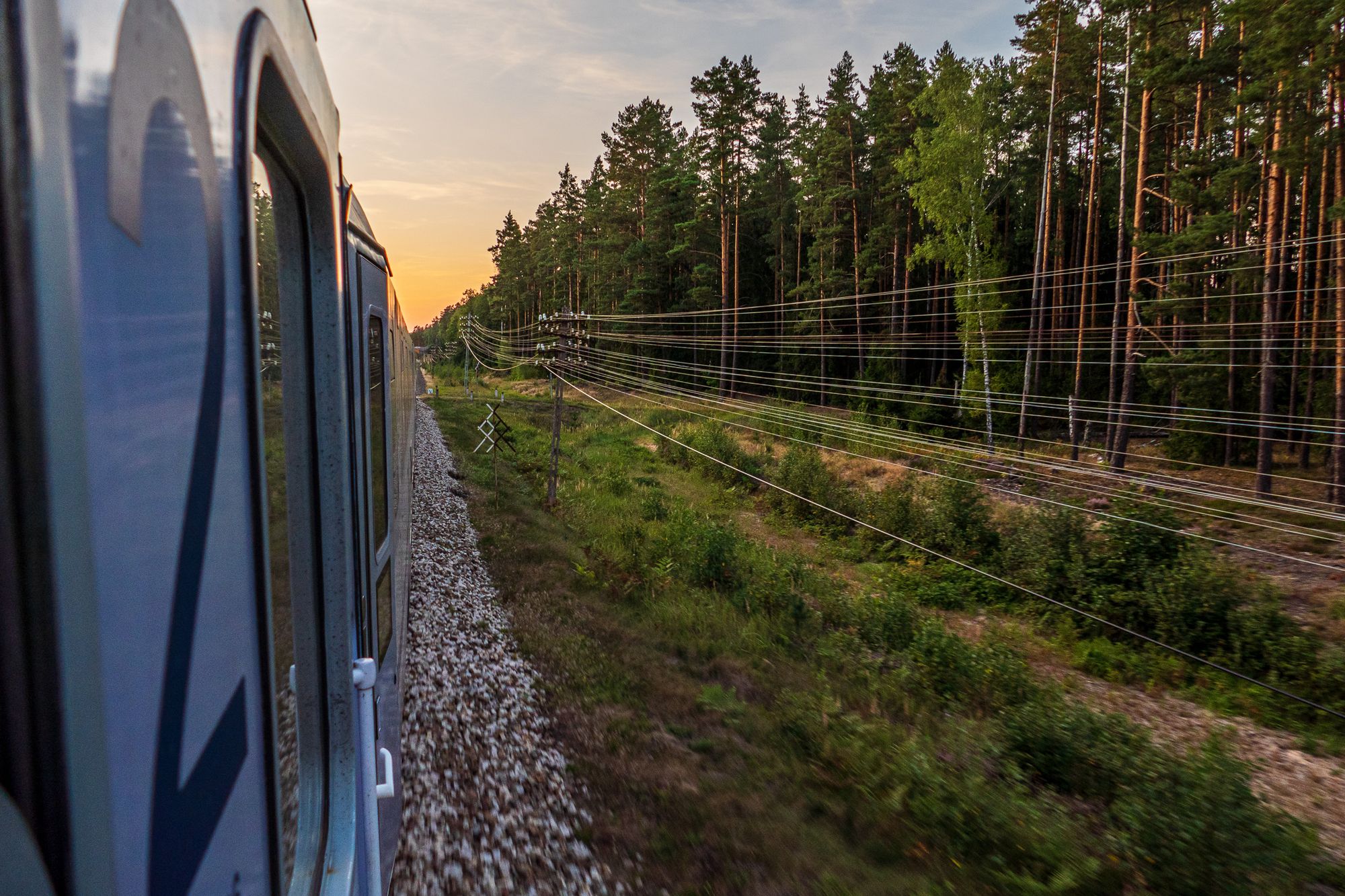 Blick aus dem Zugfenster im polnischen Zug, im Vordergrund Telegrafenkabel