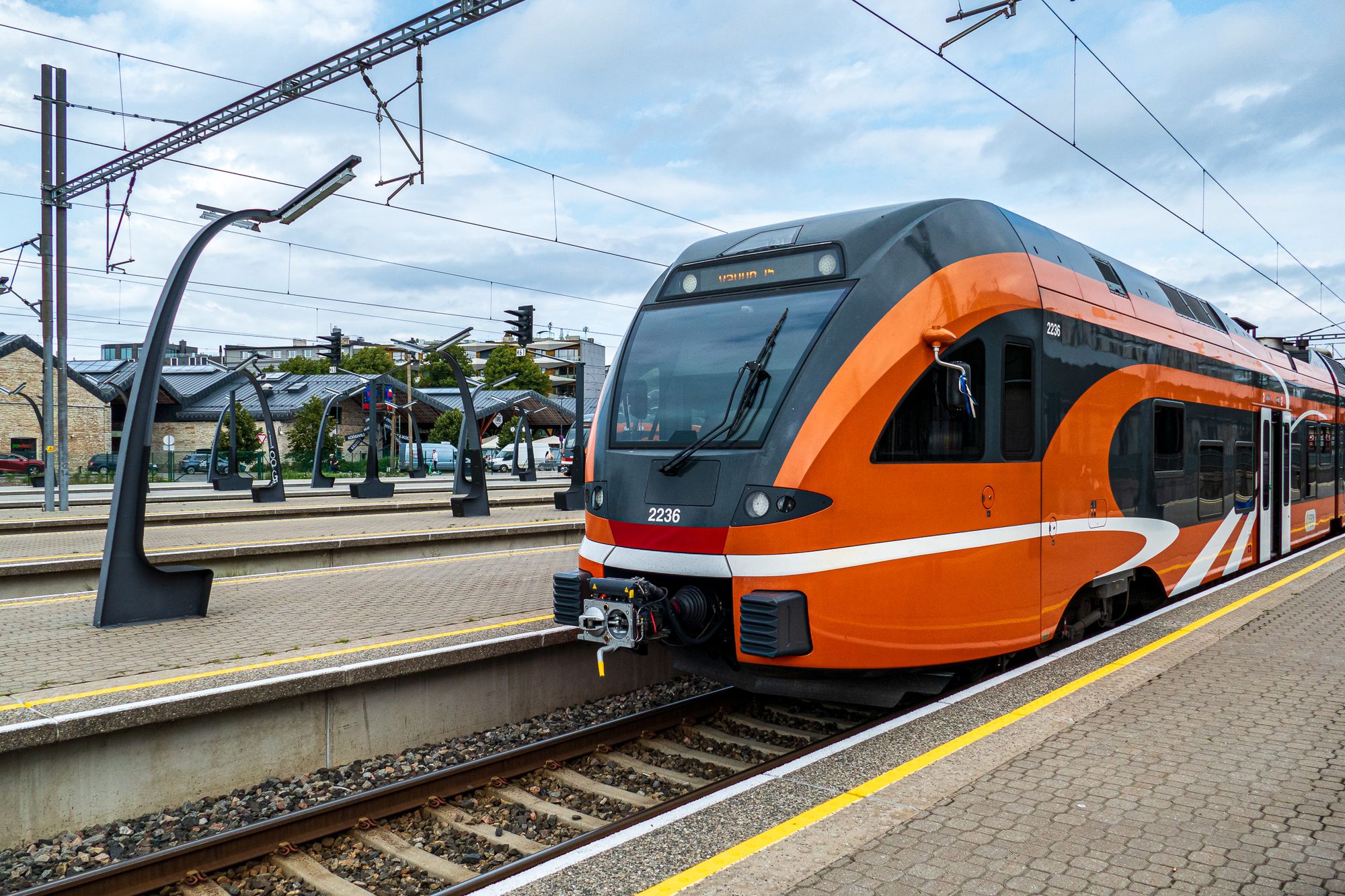 Ein oranger Triebwagen der estnischen Bahn Elron am Bahnsteig von Tallinn