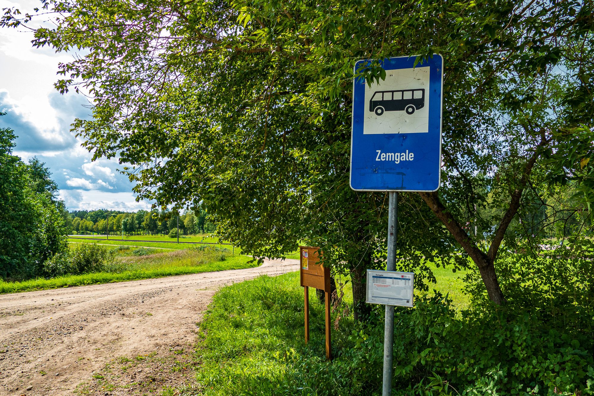 Bushaltestelle in Zemgale mit Schild und Busfahrplan
