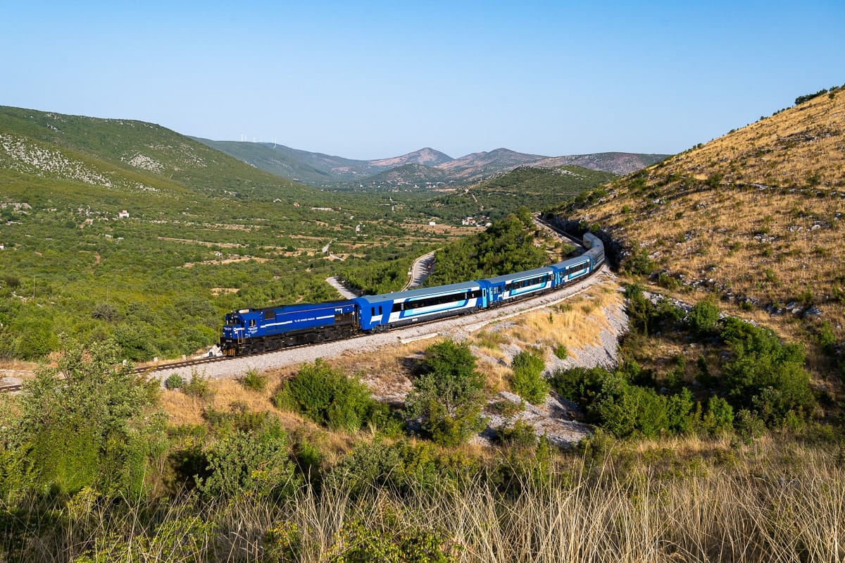 Blauer Nachtzug der Ungarischen Bahn in einer Berglandschaft in Kroatien