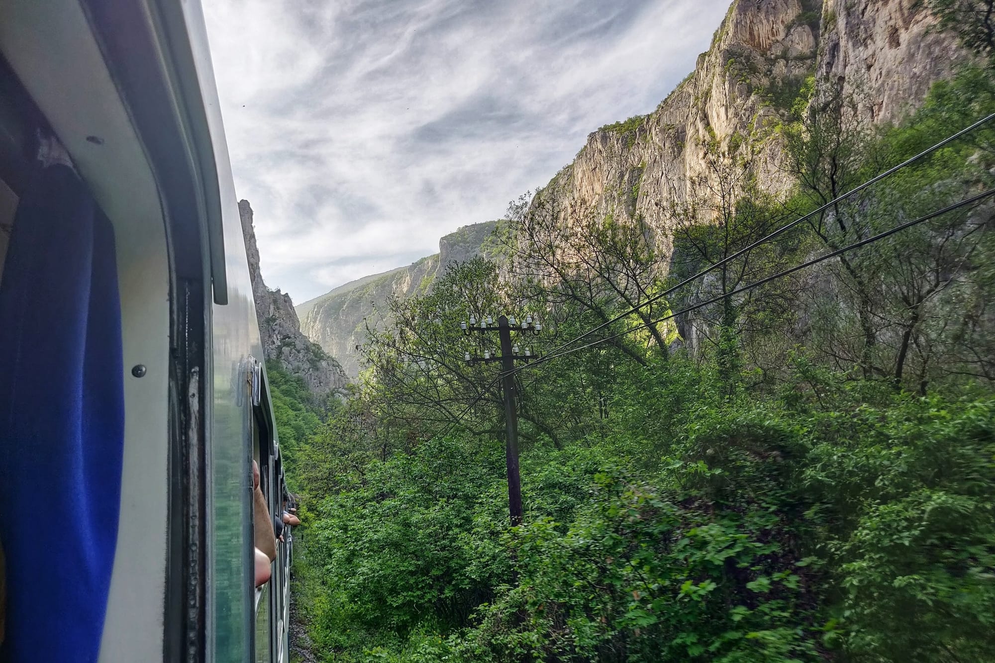 Am offenen Zugfenster durch die Berge