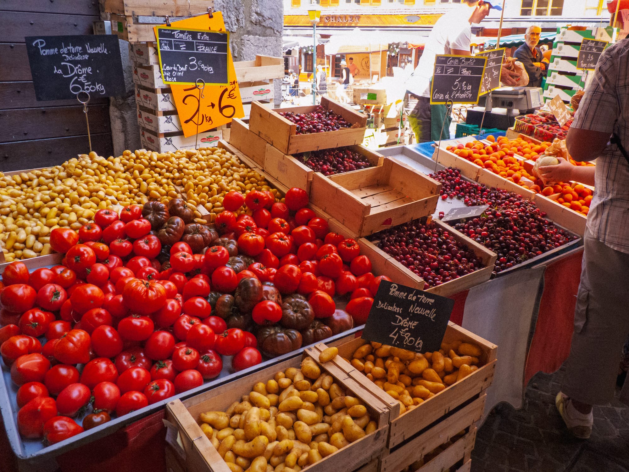 Marktstand in Annecy mit Kartoffeln, Tomaten und Früchten