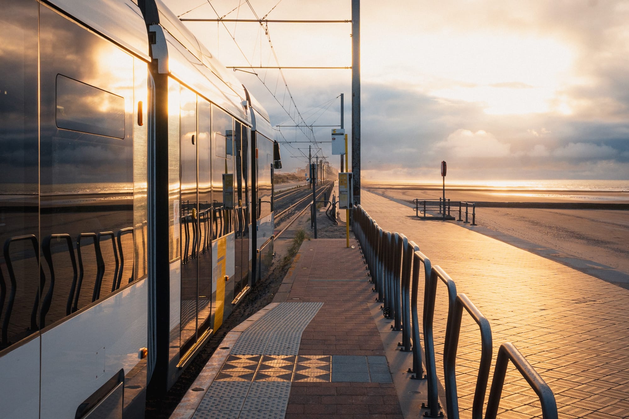 Kusttram hält am Meer im Abendlicht
